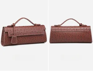 Detail view of burgundy ostrich embossed baguette bag with white contrast stitching