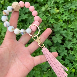 Macro view of beaded keyring bracelet with pink silicone beads and faux leather tassel
