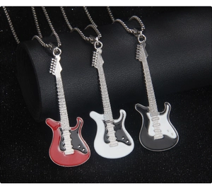 Macro shot of three guitar-shaped enamel necklaces in red, white and black colors
