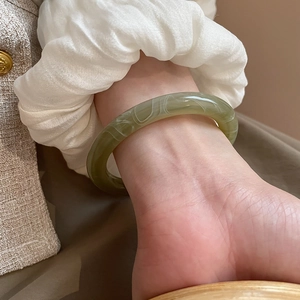 Close-up of vintage resin bangle with green marble texture worn on wrist