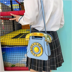 Sky blue vintage telephone crossbody bag with gold dial shown on a JK uniform outfit