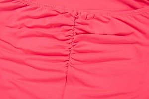 Detailed macro view of ruched stitching and knitted texture on a rose pink bodycon dress