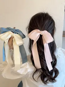 Gros plan de pinces à cheveux en satin de soie avec de longs rubans aux tons pastels