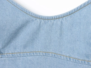 Detailansicht aus hellblauem Denim mit gelben Doppelmähten und Köperbindung Textur
