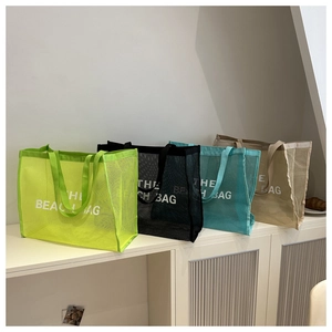 Mesh beach tote bags in multiple colors featuring The Beach Bag white lettering print