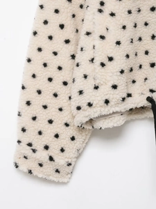 Détail de la veste en polaire à pois avec texture pelucheuse et cordons de serrage