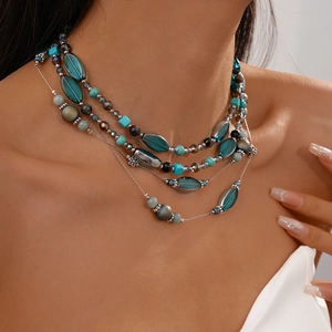Detail einer Boho-Halskette mit türkisen Glasperlen und silbernen Blumenzwischenperlen
