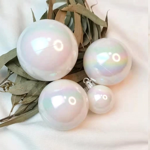 Palline di Natale bianche iridescenti con finitura perlata su sfondo di tessuto morbido