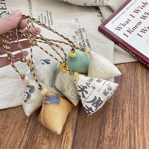 Detail of handmade Chinese Zongzi fabric pendants with traditional patterns and colorful cords