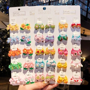 Close-up of colorful resin charms including flowers and animals on seamless hair ties