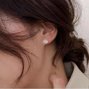Gros plan d'une puce d'oreille en argent 925 avec un brillant zircon de forme ronde