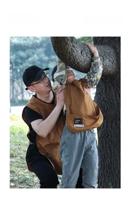 Detail view of durable brown canvas aprons for parents and kids in a forest setting