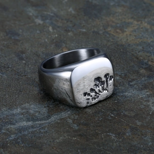 Retro Punk Ring aus poliertem Edelstahl mit Lava-Textur auf dunklem Felsen