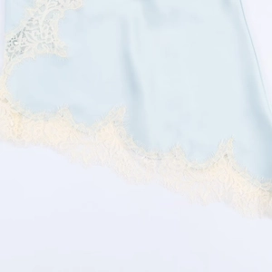 Close-up of light blue satin fabric and exquisite white eyelash lace trim detail