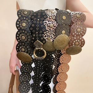 Detail of bohemian belt featuring metal rivets, leopard print, and a vintage buckle
