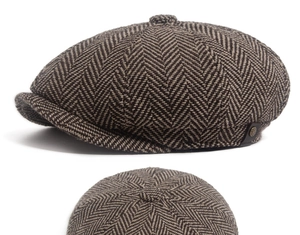 Close-up of retro brown herringbone newsboy hat showing wool texture and metal badge detail