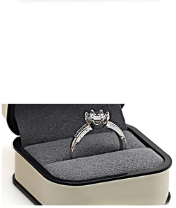Detail of a solitaire ring with textured band inside a premium beige PU leather jewelry box