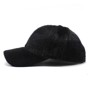 Side view of a thick black faux fur baseball cap for winter warmth and outdoor style