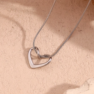 Macro shot of silver minimalist hollow heart pendant with a fine snake chain necklace