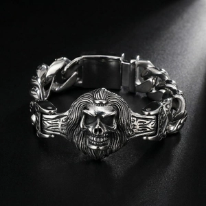 Macro detail of gothic skull sculpture and heavy link chain on men's steel bracelet