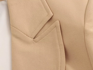Detailed close-up of camel blazer collar showing premium grain texture and fine stitching