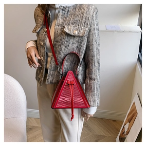 Close-up of red triangular bag featuring sparkling silver rhinestones and drawstring closure