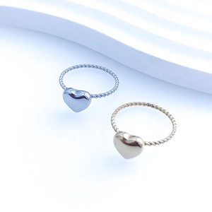 Detailed macro view of heart-shaped stainless steel rings with twisted rope band design