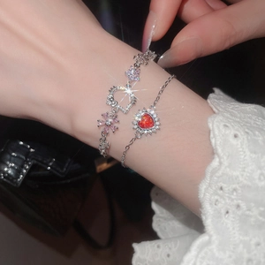 Detail of Hello Kitty and red heart charms on silver bracelets with zircon accents