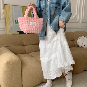 Pink popcorn textured bubble tote bag detail shown in a cozy lifestyle indoor setting