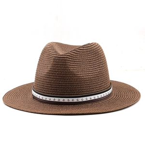 Détail d'un chapeau de paille marron avec ruban blanc et rivets en forme d'étoiles