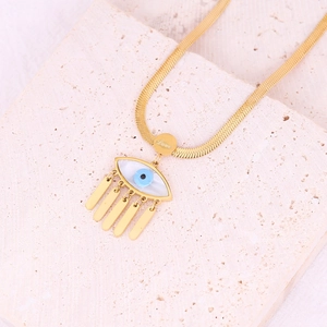 Detail of gold snake chain with evil eye pendant and Love engraved charm on stone