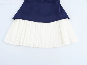 Détail de l'ourlet contrasté en tissu bleu marine et texture plissée blanc crème