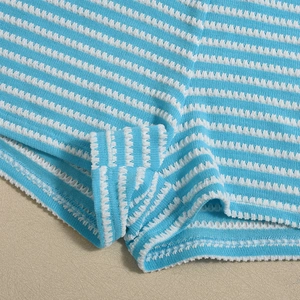 Macro detail of blue and white striped knit fabric with waffle texture and neat hem