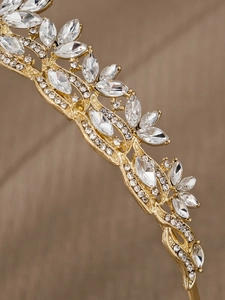 Detailed close-up of golden bridal tiara with marquise rhinestones and floral patterns