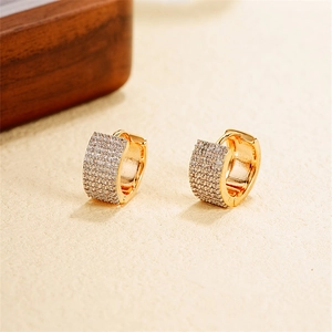 Macro shot of gold U-shaped earrings featuring rows of sparkling pavé cubic zirconia