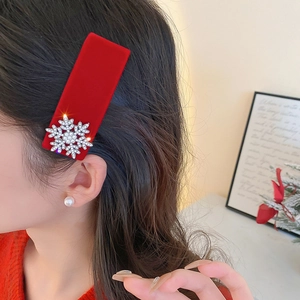 Close-up of red velvet hair clip with sparkling silver rhinestone snowflake design