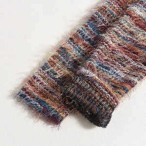 Macro shot of colorful feathered yarn knit fabric texture showing detail of cuffs and hem