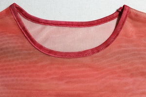 Detailed close-up of the red mesh fabric round neckline and breathable mesh structure