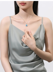 Detail of a S925 sterling silver necklace with sunflower-shaped blue gemstone pendant