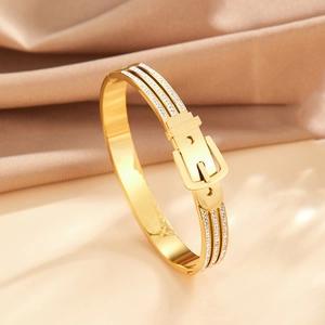 Detail of gold buckle bracelet with sparkling zircon pavé and Fashion engraving