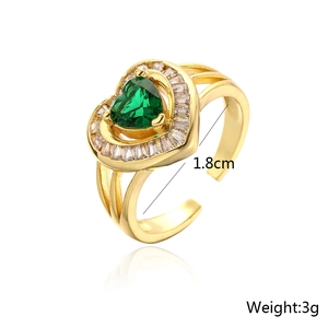 Detail view of 18K gold plated heart ring with green gemstone and white baguette stones