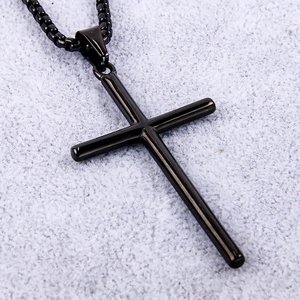 Macro shot of polished black stainless steel cross pendant with matching box chain