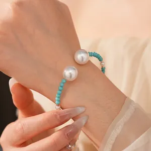 Bracelet vintage français en perles avec perles bleues sur un poignet de femme