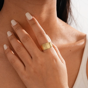 Macro shot of gold multi-layer wrap ring showing metallic luster on model finger