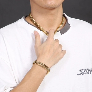 Close-up of golden Cuban link necklace and bracelet set with sparkling rhinestone clasps