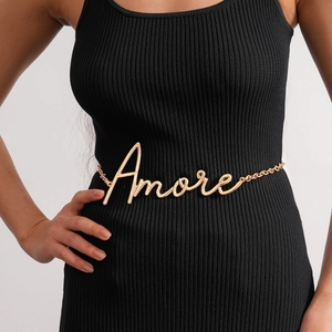Professionelles Detail einer goldenen Amore-Hüftkette auf einem stilvollen schwarzen Kleid.