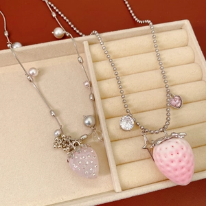 Detail of sweet strawberry necklaces with pearls and pink crystals in a jewelry box