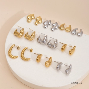 Collection of polished gold and silver titanium steel earrings on a stone display