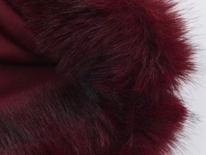 Macro shot of deep red faux fur trim on garment showing rich texture and fibers
