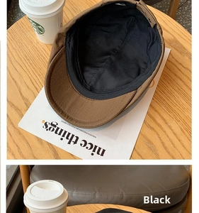 Close-up of brown synthetic leather newsboy cap with black lining on a wooden table